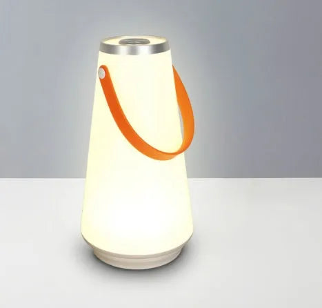 White rechargeable LED bedside night light with touch control on a wooden table.