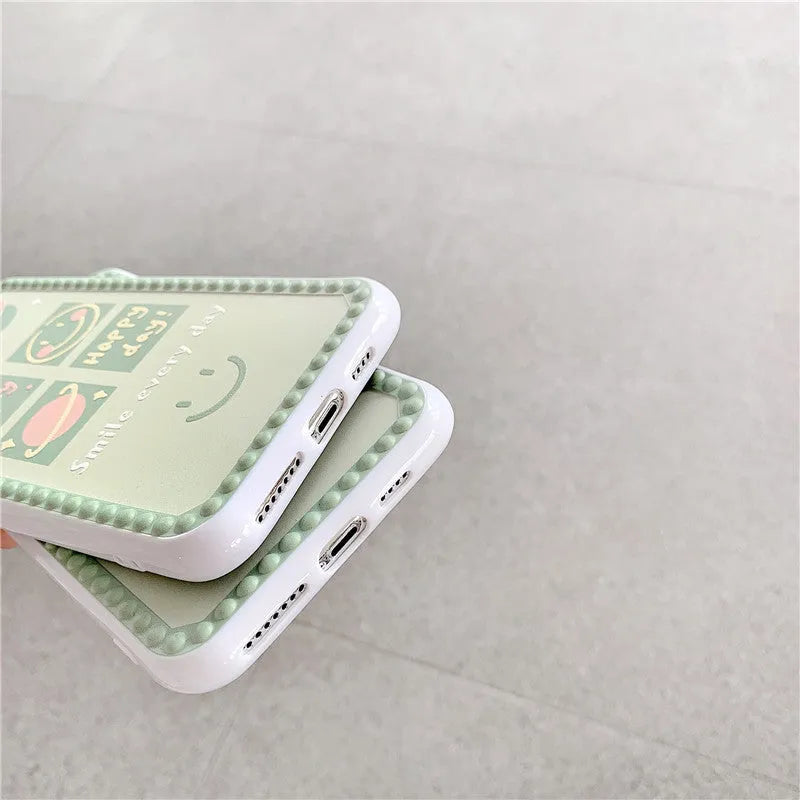 Green TPU iPhone case with a smiley face geometric pattern and polka dot frame.
