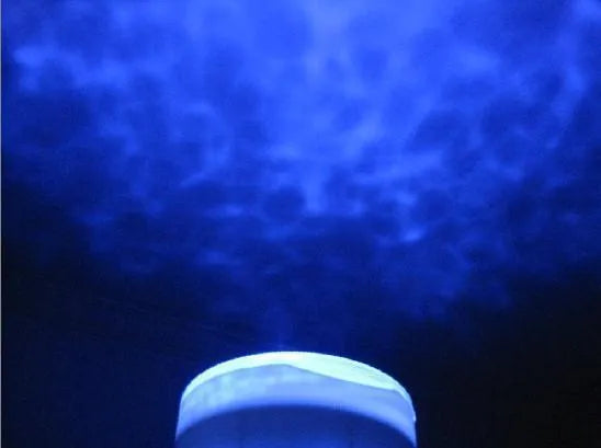 A blue ocean-themed LED projection lamp displaying aquatic imagery on a wall.