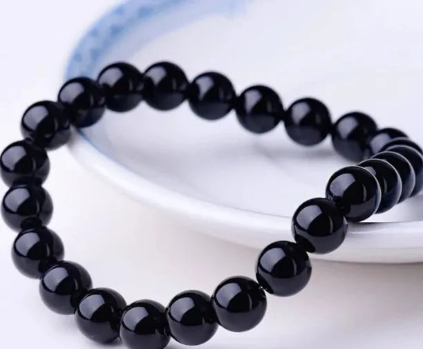 Geometric black onyx bracelet with 8mm agate beads on a black elastic cord.