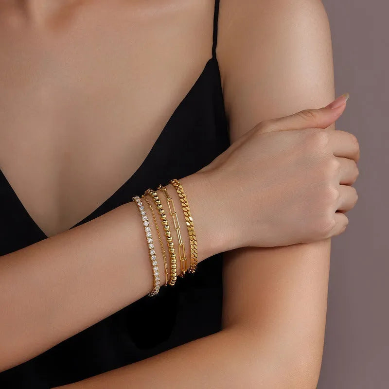 Five stacked S925 silver gold bracelets with round moissanite stones in geometric mosaic design on white background
