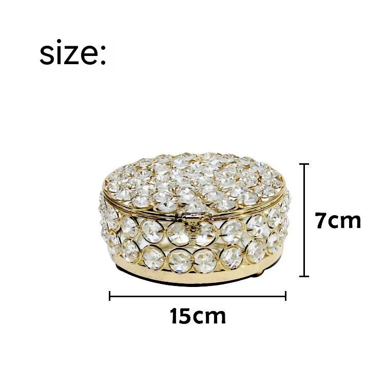 Transparent crystal glass jewelry storage box with ornate French gold metal frame.