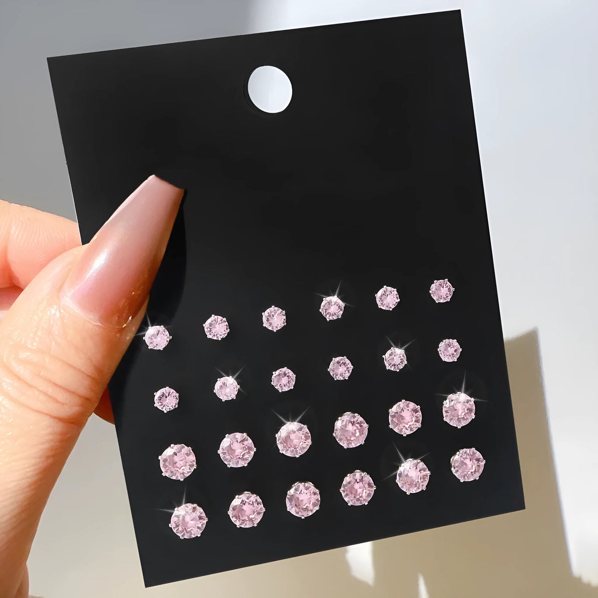Pink round women's earrings set of 12 pairs on display, alloy with electroplated finish, geometric stud style