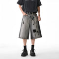Grey denim shorts with loose fit and cropped length on hanger