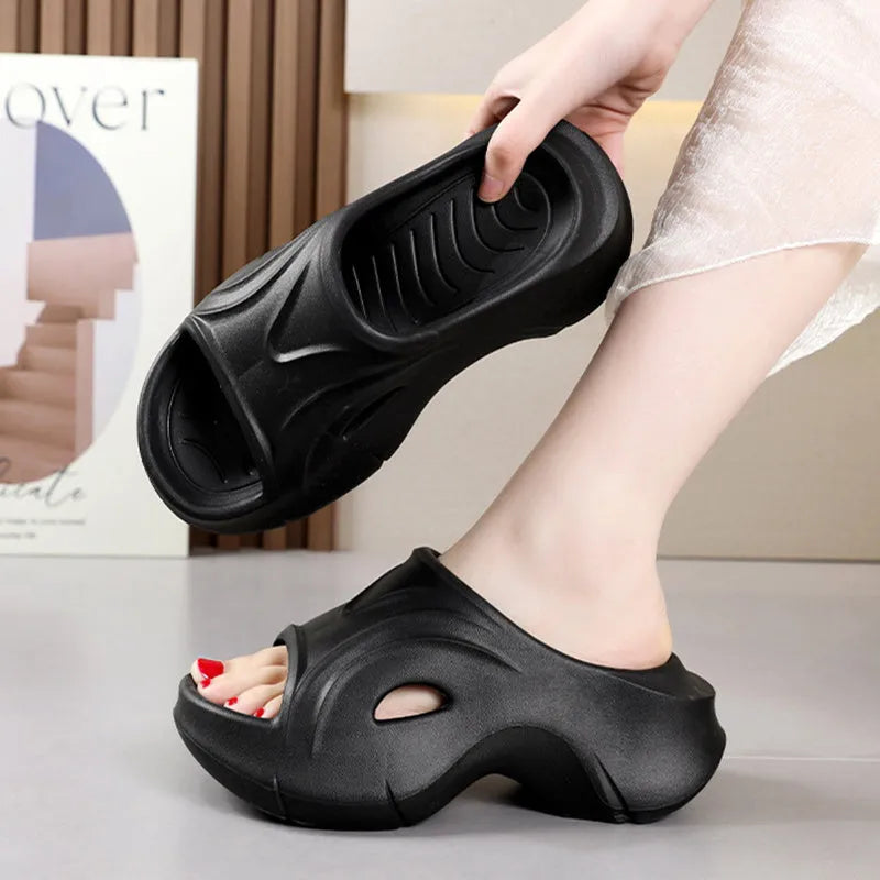 Women's white thick-soled EVA beach slippers with round toe on sand.