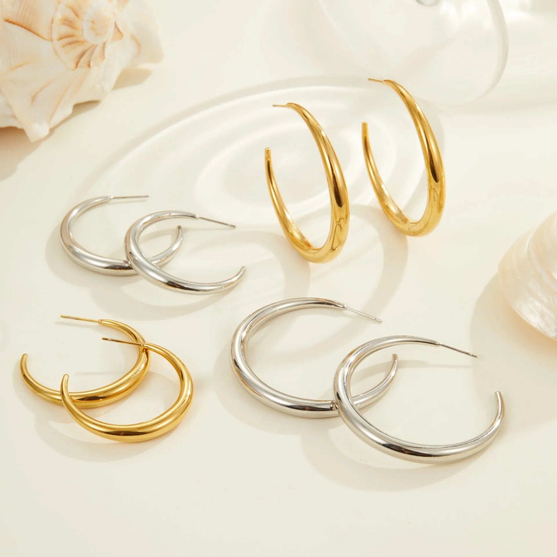 Titanium steel hoop earrings in geometric round design with gold or steel finishes