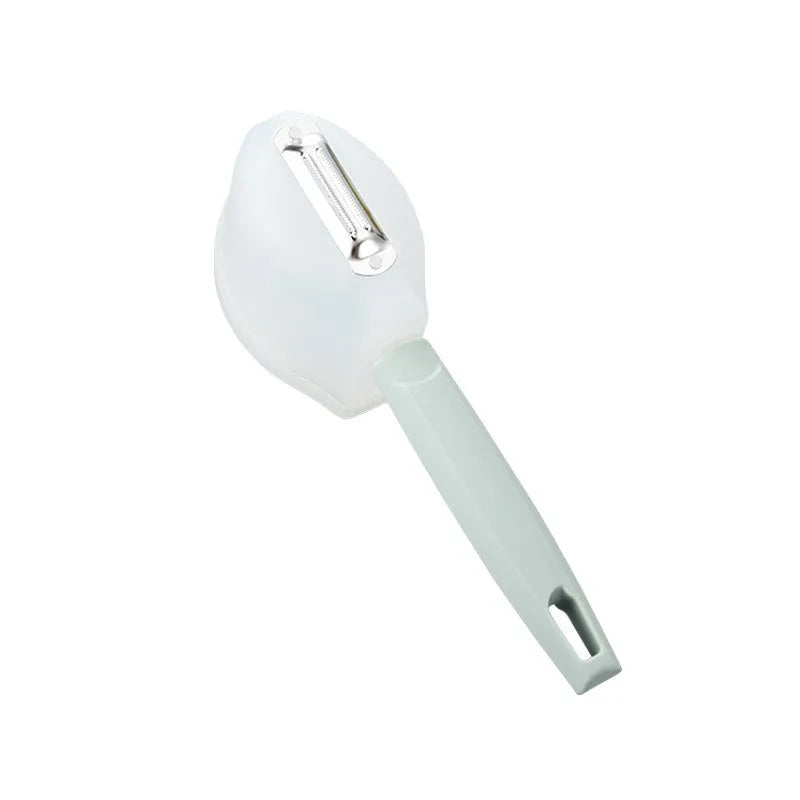 Stainless steel handle fruit peeler in pink colour with PP plastic body on a wooden surface