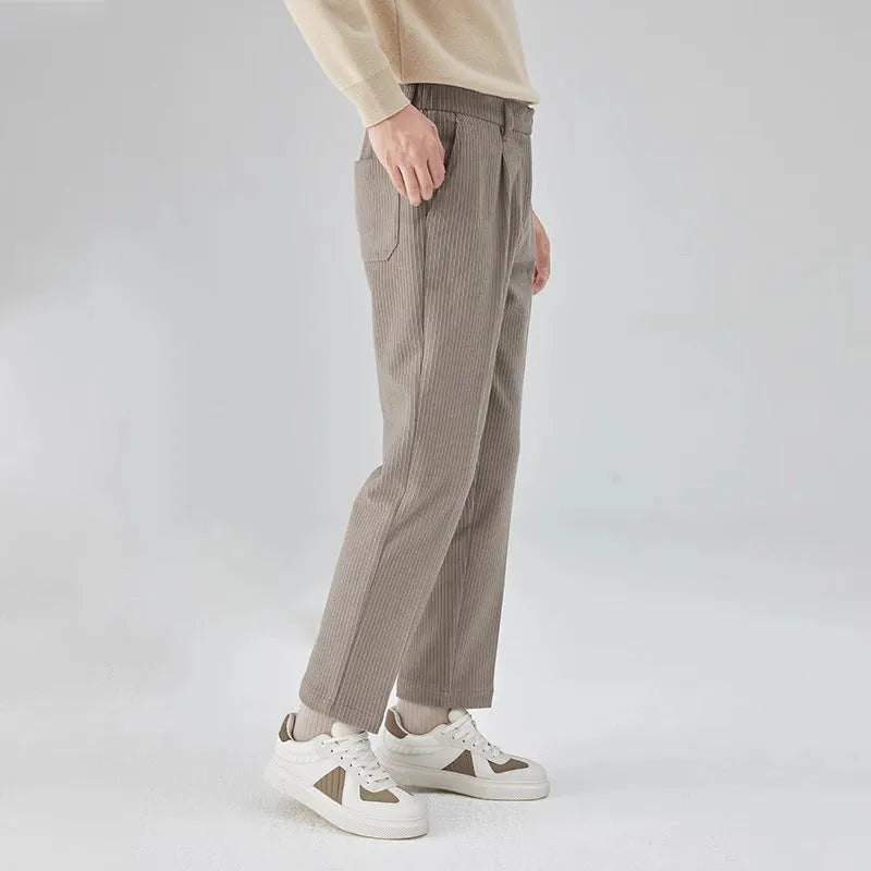 Men's straight-leg corduroy trousers in beige, shown laid flat to display the mid-waist and textured fabric.