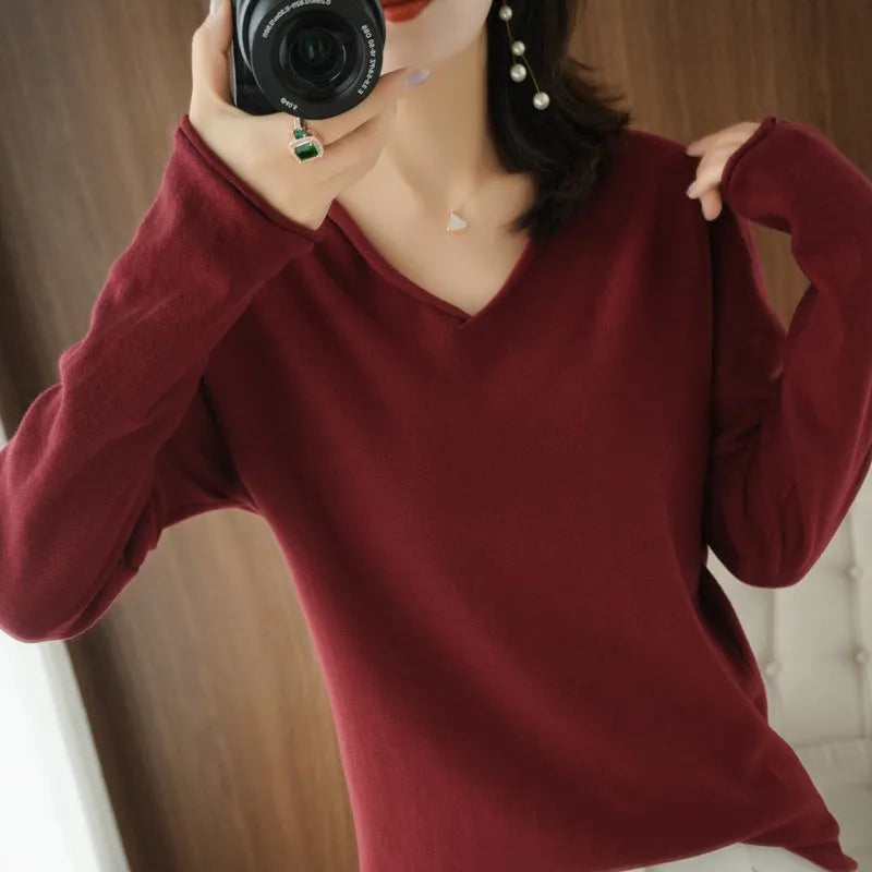 Women's long sleeve V-neck knitwear top in turmeric colour, laid flat to show pullover style and non-ironing fabric.