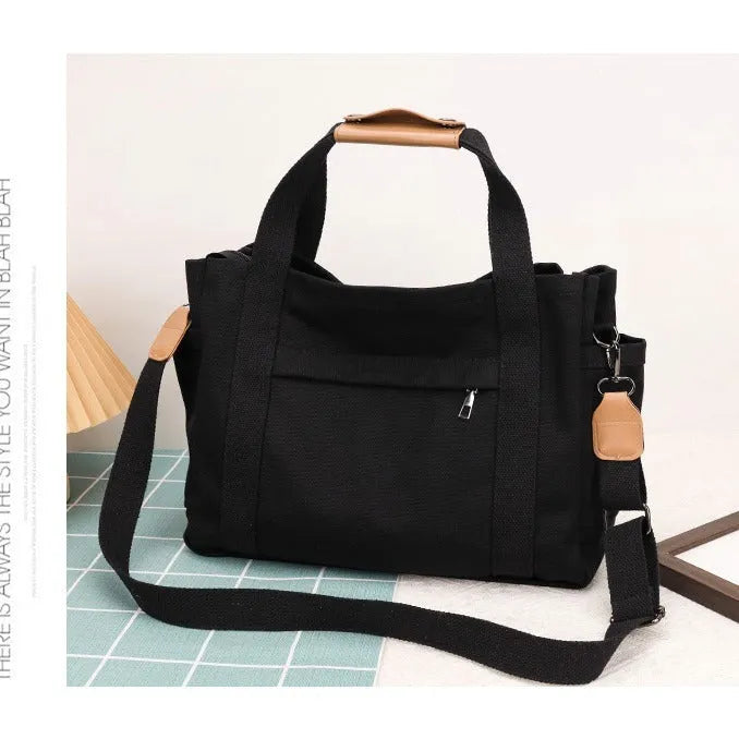 Canvas crossbody tote bag in khaki with open zipper showing internal organiser pockets.