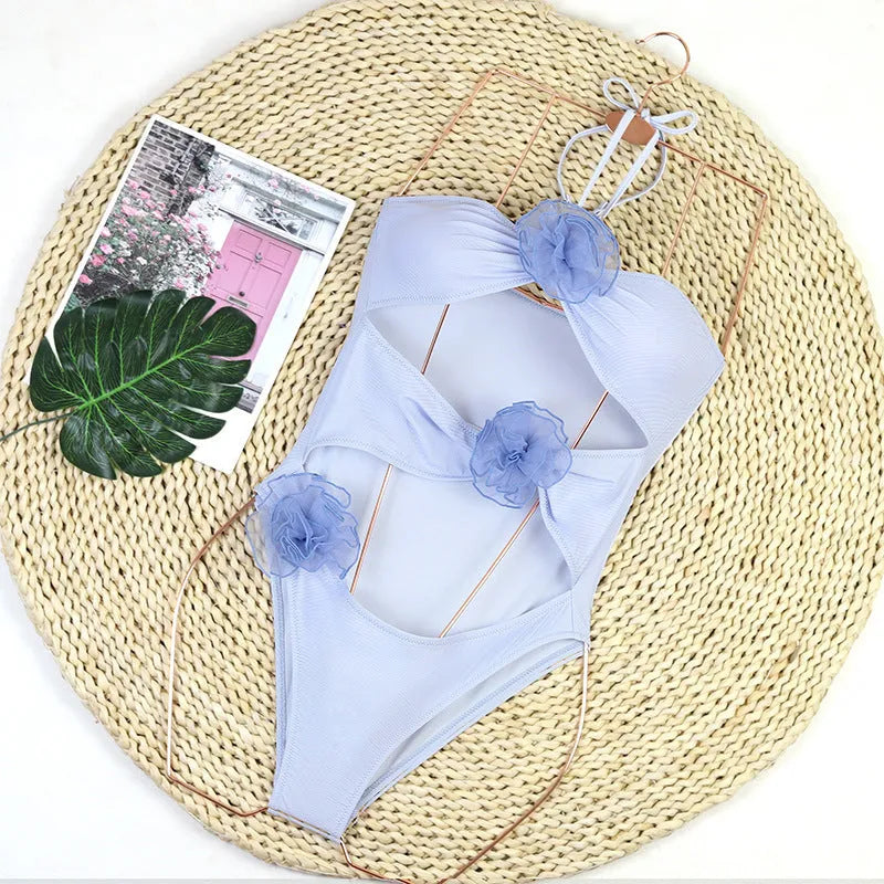 Women's black one-piece swimsuit with 3D white flower detail on the front