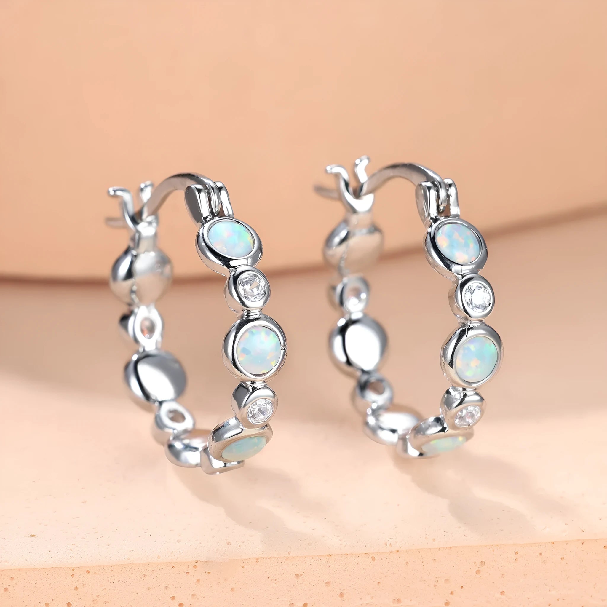 Round copper earrings with synthetic opal and cubic zirconia in platinum white finish