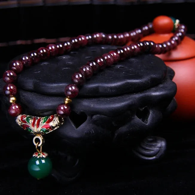 Natural garnet bracelet with 7mm beads, double gold ring clasp, and golden toad charm.