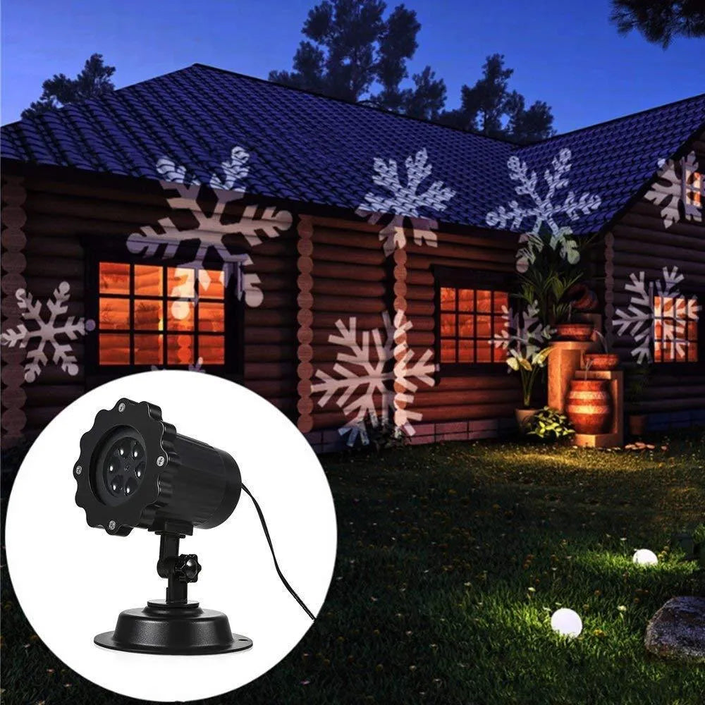 LED Christmas snowflake laser projector with white moving patterns on a dark garden wall at night