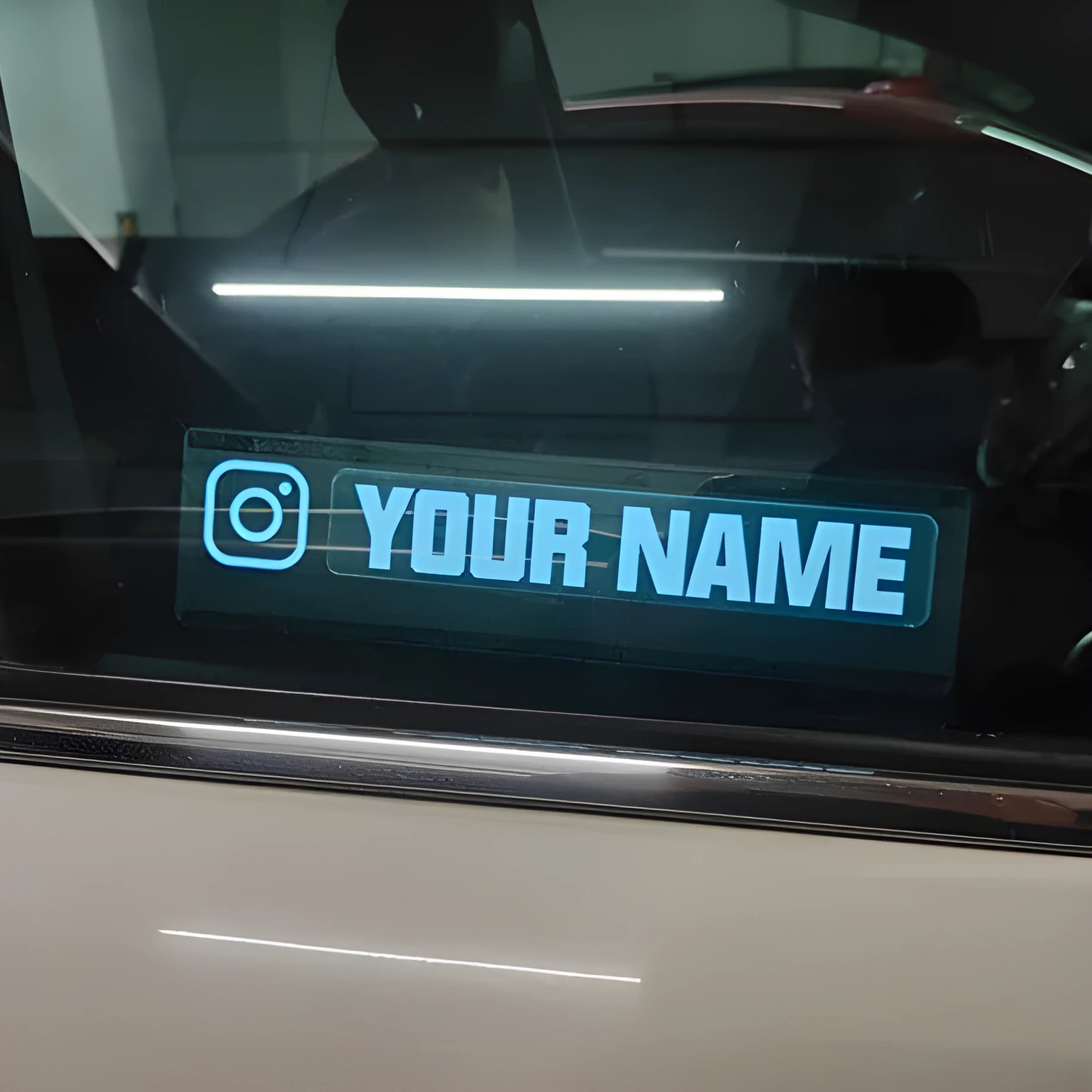 Electroluminescent car window sticker glowing white on a 0.5mm thick panel.
