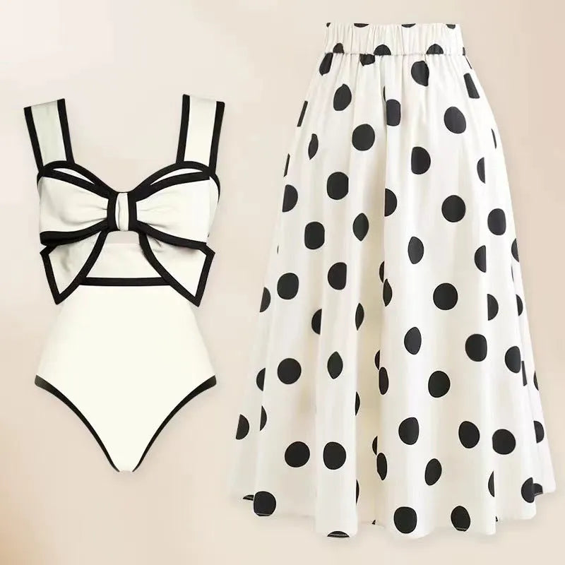 Women's black one-piece swimsuit with attached round skirt and decorative bow detail