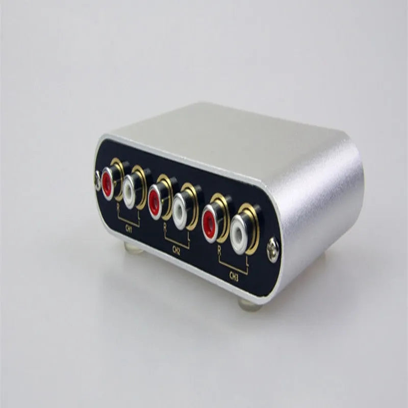 Silver aluminium alloy audio source selector switch unit with front-panel buttons and infrared remote.