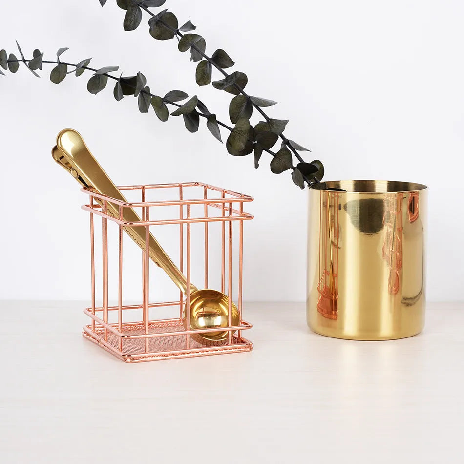 Rose gold iron wire square pen holder on desk holding pens and a ruler