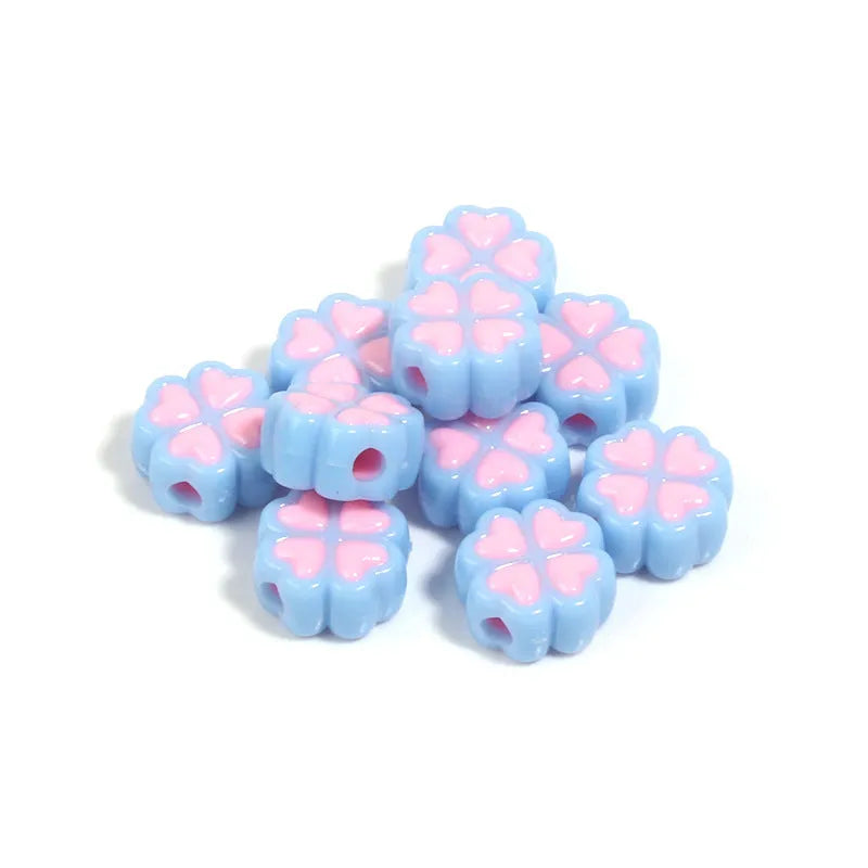 Frosted acrylic four-leaf clover shaped beads in mixed colours on white background