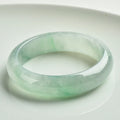 Light green jade bracelet showing natural stone texture on wrist