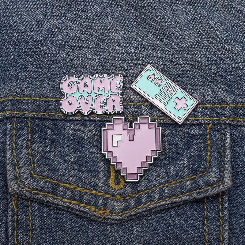 A three-dimensional die-cast alloy metal badge shaped like a stereo game console.