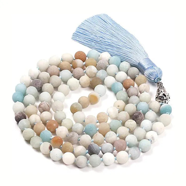 Long agate tassel necklace with geometric beads in multiple natural stone colours on a white background.