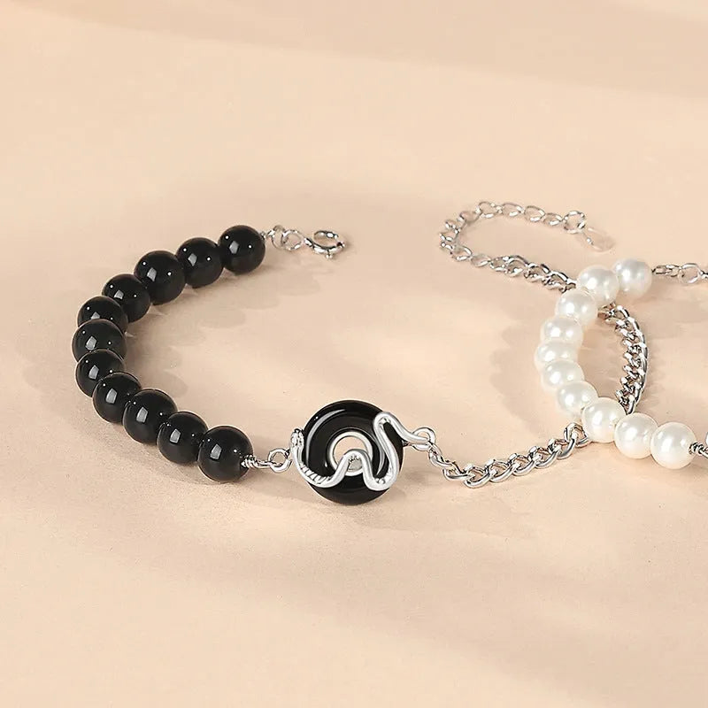 Close-up of a 925 sterling silver bracelet with a safe buckle, featuring obsidian pearls and a detailed snake charm in a new Chinese style.