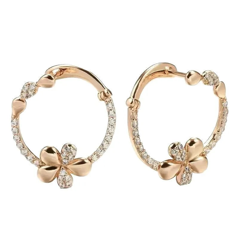 A pair of round gold-coloured hoop earrings with a geometric ring design on a plain background.