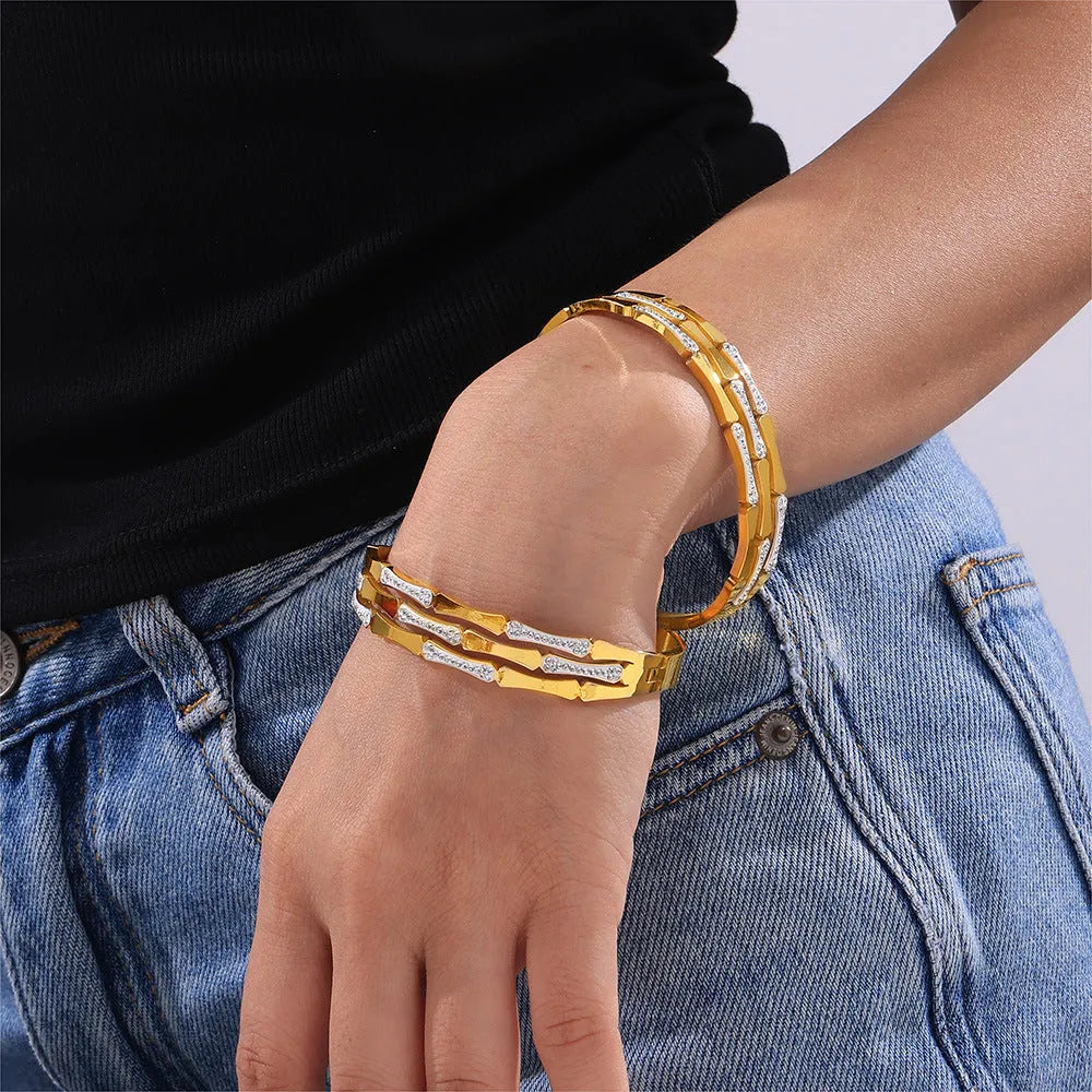 Gold electroplated titanium steel hollow splicing casual bracelet for women, open cuff design on white background