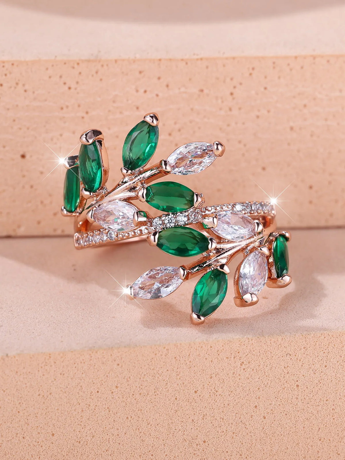 Adjustable copper leaf ring in platinum or rose gold finish on a white background
