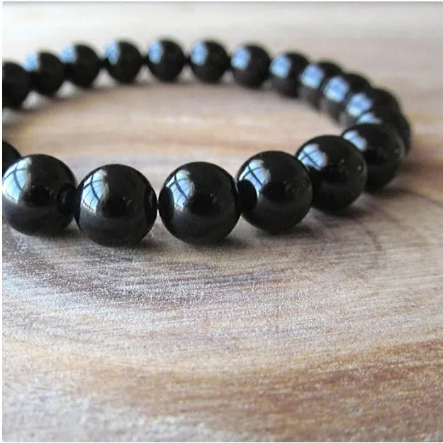 Geometric black onyx bracelet with 8mm agate beads on a black elastic cord.