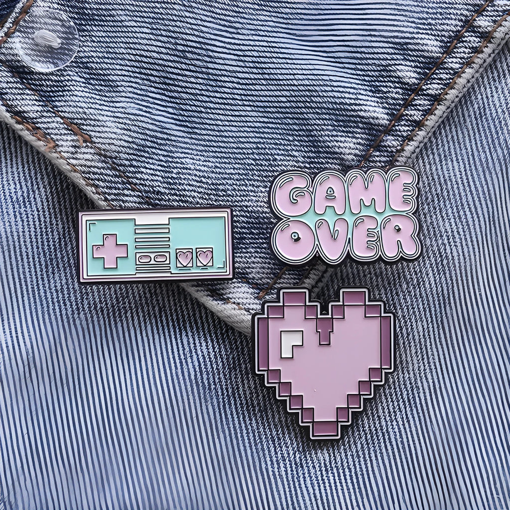A three-dimensional die-cast alloy metal badge shaped like a stereo game console.