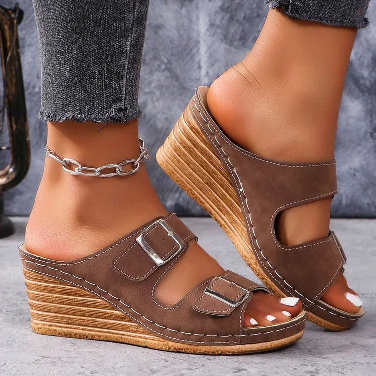 Women's wedge slippers with an outer buckle closure in creamy-white colour on a rubber sole.