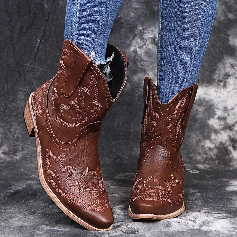 Women's brown cowboy boots with embroidery on the shaft, pointed toe, and a low wedge heel.