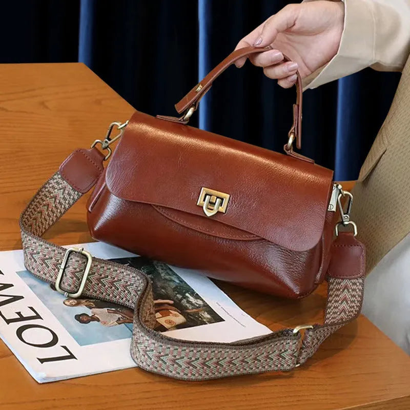 Women's brown leather saddleback handbag with double straps and multiple compartments