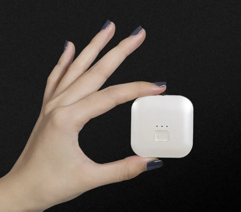 Small pink wearable USB air purifier necklace on a person, showing compact size.