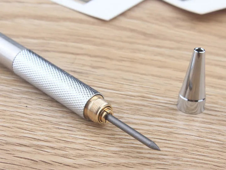 Silver metal automatic mechanical pencil with six compatible lead sizes from 0.5mm to 2.0mm on a notebook.