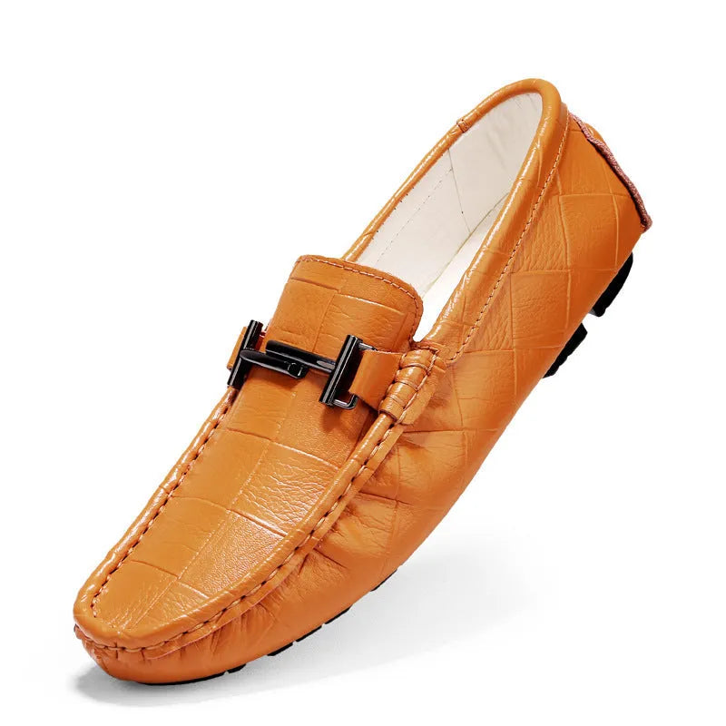 Men's brown leather casual shoes with a silver belt buckle on the side and a flat rubber sole.