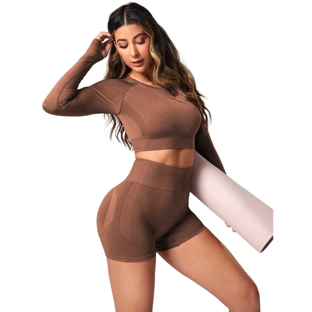 Women's black yoga set comprising a long sleeve top and high-waist trousers laid flat.