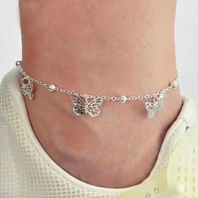 Alloy hollow butterfly design anklet in gold finish on a woman's ankle, beach foot ornament style