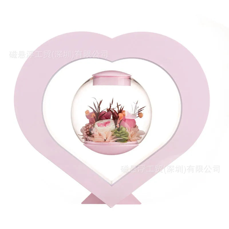 Pink preserved rose ornament gift with optional Bluetooth audio base on a wooden table.