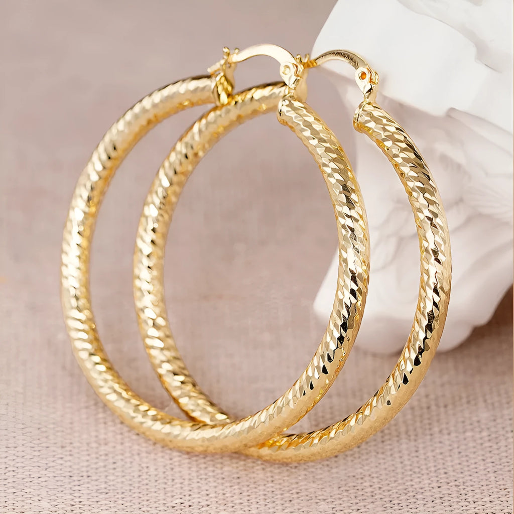A pair of women's geometric drop-shaped clip-on earrings with a ring design in an electroplated copper finish.