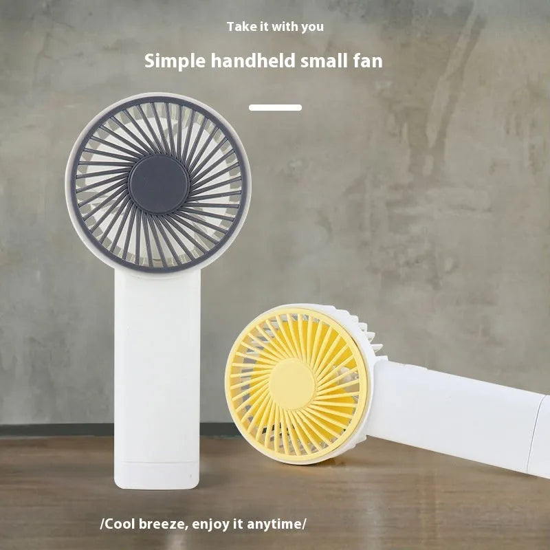 Outdoor portable USB rechargeable handheld fan in pink with three plastic blades and single speed button