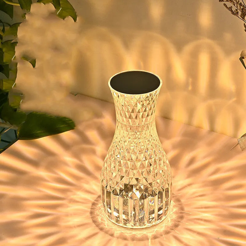 Crystal vase-shaped table lamp with remote control on wooden bedside table
