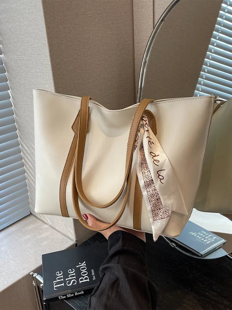 Women's soft bucket tote bag in multiple colours with crossbody strap and zippered internal compartment