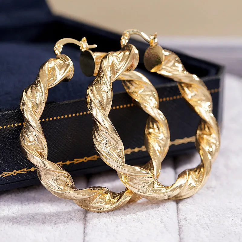 A pair of women's geometric drop-shaped clip-on earrings with a ring design in an electroplated copper finish.