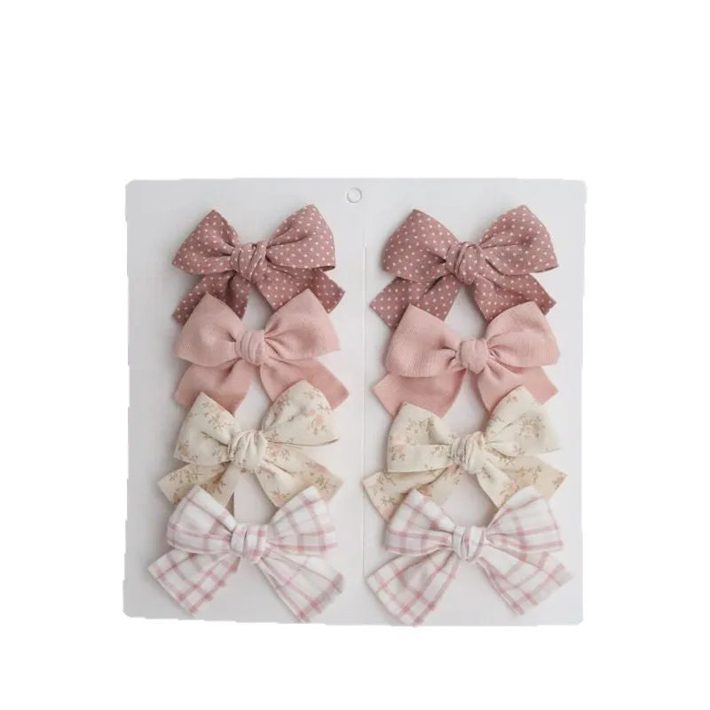 Children's cloth bow hairclip set showing dovetail shape in multiple colour options
