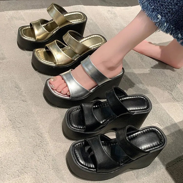 Women's black wedge platform slippers with square toe design on grey background