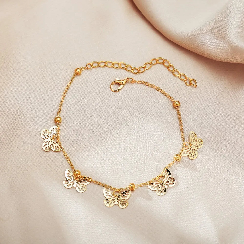 Alloy hollow butterfly design anklet in gold finish on a woman's ankle, beach foot ornament style
