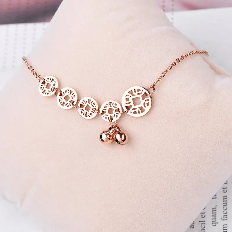 Rose gold stainless steel anklet with coin charms and small bells on adjustable link chain